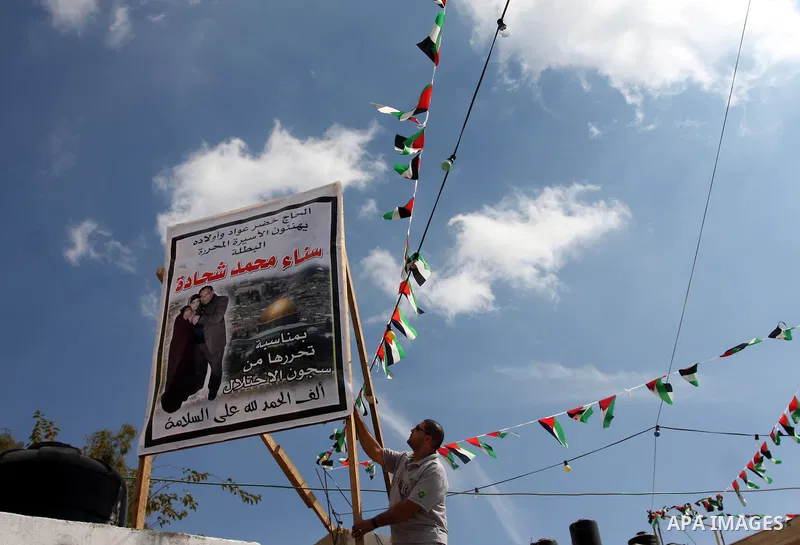 Palestinians decorate a building ahead of the release of Sana'a Shahada shown in banner, in the West Bank city of Ramallah, Monday, Oct. 17, 2011. Shahada is scheduled to be released on Tuesday in an exchange between Isr...