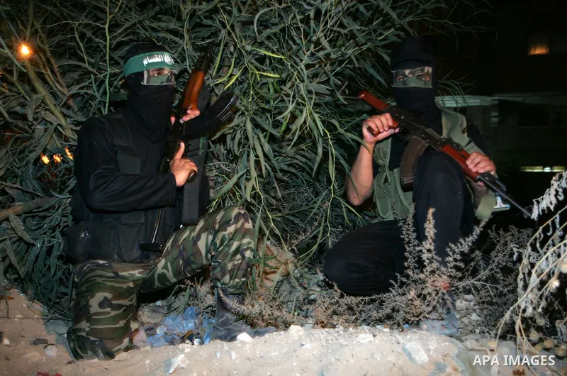Palestinian Hamas militants stand guard on the main road in Khan Younis, southern Gaza Strip, Monday, Oct. 17, 2011. The exchange between Israel and Hamas in which 1,027 Palestinian prisoners will be released for capture...