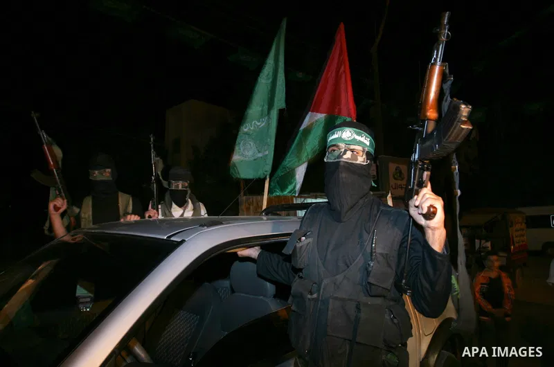 Palestinian Hamas militants stand guard on the main road in Khan Younis, southern Gaza Strip, Monday, Oct. 17, 2011. The exchange between Israel and Hamas in which 1,027 Palestinian prisoners will be released for capture...
