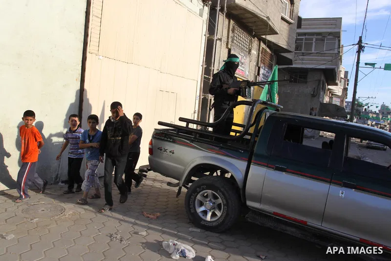 Armed Palestinian Hamas militants stand guard at a street in Gaza city on October 18, 2011 as an Israeli-Palestinian prisoner swap deal gets under way. Buses carrying 477 Palestinian prisoners were headed for Gaza and th...