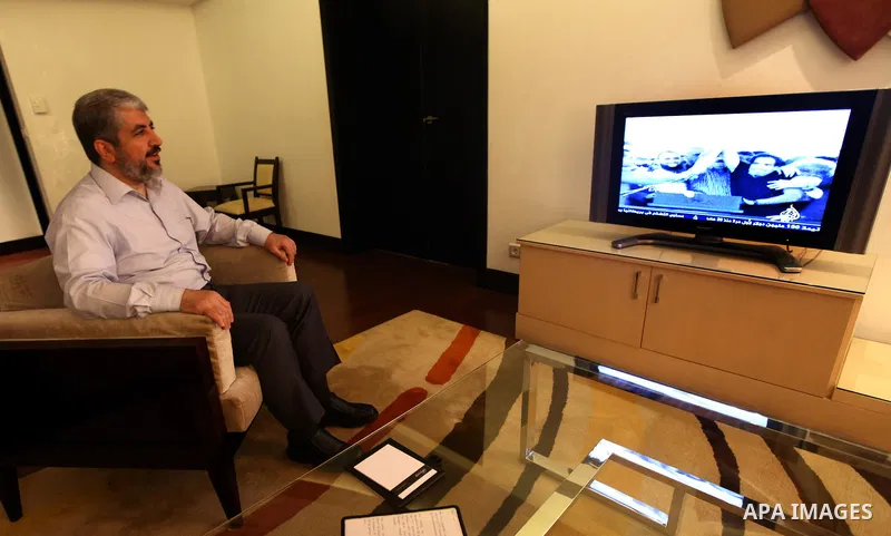 Palestinian Hamas leader Khaled Meshaal watches TV in at his residential headquarters in Cairo, Egypt Oct. 18,2011. Gaza's Hamas Islamist rulers released captured Israeli soldier Gilad Shalit on Tuesday in return for hun...