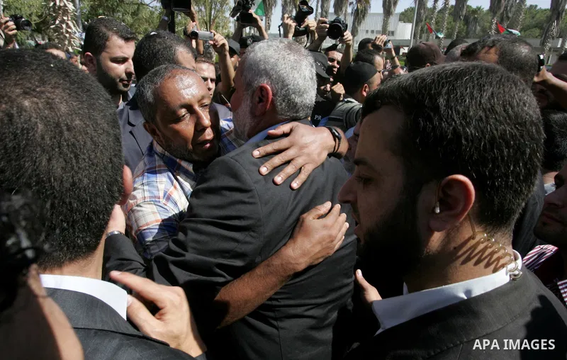Palestinian Prime Minister in Gaza Strip, Ismail Haniyeh greets a released Palestinian prisoner at the Rafah border crossing in southern Gaza Strip, Tuesday, Oct. 18, 2011. The Hamas militant group released an Israeli so...