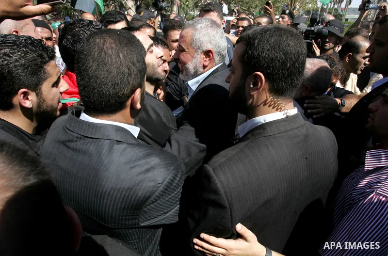 Palestinian Prime Minister in Gaza Strip, Ismail Haniyeh greets a released Palestinian prisoner at the Rafah border crossing in southern Gaza Strip, Tuesday, Oct. 18, 2011. The Hamas militant group released an Israeli so...