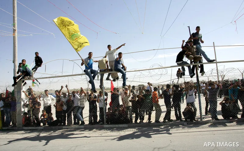 Palestinian youths celebrate the release of prisoners at the Rafah border crossing in southern Gaza Strip, Tuesday, Oct. 18, 2011. Tens of thousands of flag-waving Palestinians on Tuesday celebrated the homecoming of hun...