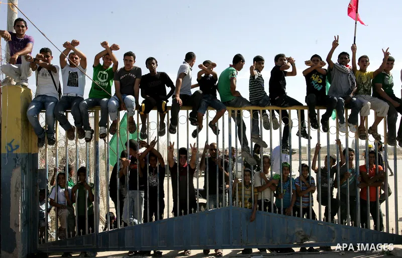 Palestinian youths celebrate the release of prisoners at the Rafah border crossing in southern Gaza Strip, Tuesday, Oct. 18, 2011. Tens of thousands of flag-waving Palestinians on Tuesday celebrated the homecoming of hun...