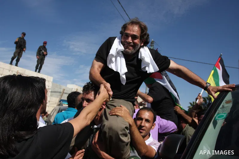 A Palestinian prisoner is welcomed by a crowd following the release of hundreds of prisoners from Israeli jails on October 18,2011 at the Palestinian Authority headquarters in the West Bank city of Ramallah. Crowds of Pa...