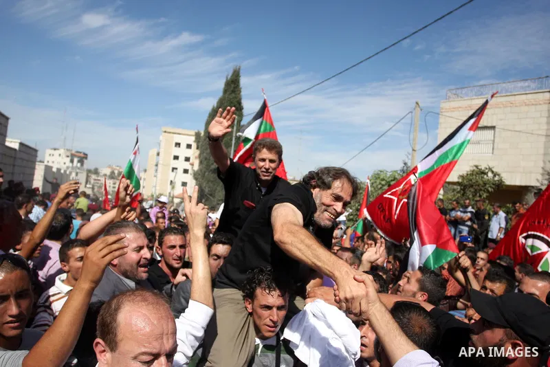 A Palestinian prisoner is welcomed by a crowd following the release of hundreds of prisoners from Israeli jails on October 18,2011 at the Palestinian Authority headquarters in the West Bank city of Ramallah. Crowds of Pa...