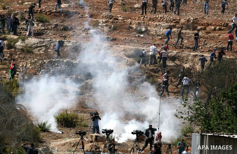 Palestinians run to take cover from tear gas fired by Israeli troops while they wait for released prisoners outside the Ofer prison near the West Bank city of Ramallah on Oct. 18, 2011. Hamas and Israel reached a prison...