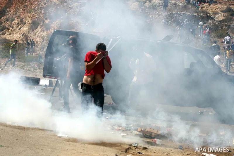 Palestinians run to take cover from tear gas fired by Israeli troops while they wait for released prisoners outside the Ofer prison near the West Bank city of Ramallah on Oct. 18, 2011. Hamas and Israel reached a prison...
