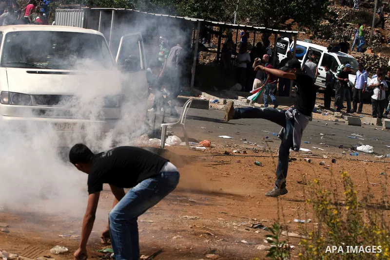 Palestinians run to take cover from tear gas fired by Israeli troops while they wait for released prisoners outside the Ofer prison near the West Bank city of Ramallah on Oct. 18, 2011. Hamas and Israel reached a prison...