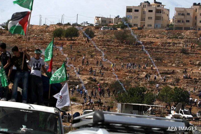 Palestinians run to take cover from tear gas fired by Israeli troops while they wait for released prisoners outside the Ofer prison near the West Bank city of Ramallah on Oct. 18, 2011. Hamas and Israel reached a prison...
