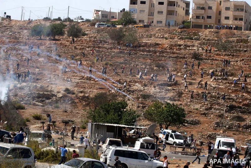 Palestinians run to take cover from tear gas fired by Israeli troops while they wait for released prisoners outside the Ofer prison near the West Bank city of Ramallah on Oct. 18, 2011. Hamas and Israel reached a prison...