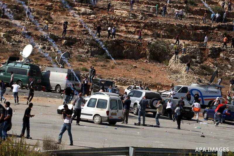 Palestinians run to take cover from tear gas fired by Israeli troops while they wait for released prisoners outside the Ofer prison near the West Bank city of Ramallah on Oct. 18, 2011. Hamas and Israel reached a prison...
