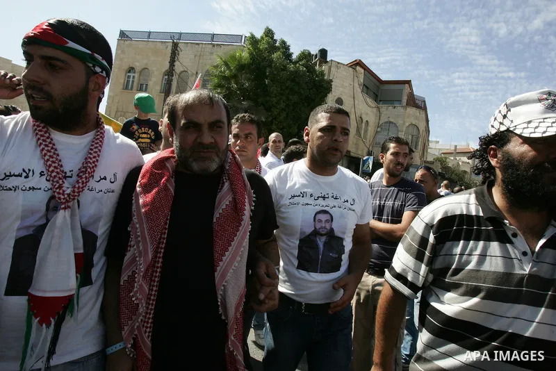 Newly released Palestinian prisoner Adnan Maragha (C) waves flags as he is carried by greeters in the Arab east Jerusalem neighbourhood of Ras al-Amud October 18, 2011. Israeli soldier Gilad Shalit and hundreds of Palest...