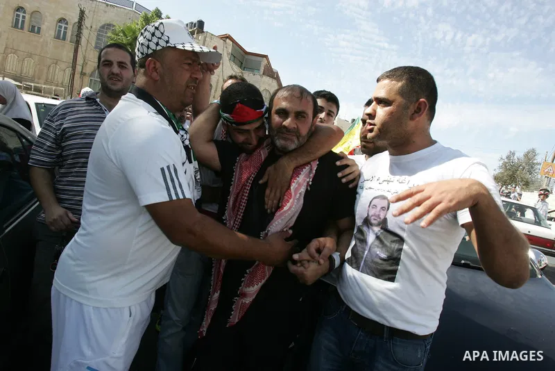 Newly released Palestinian prisoner Adnan Maragha (C) waves flags as he is carried by greeters in the Arab east Jerusalem neighbourhood of Ras al-Amud October 18, 2011. Israeli soldier Gilad Shalit and hundreds of Palest...