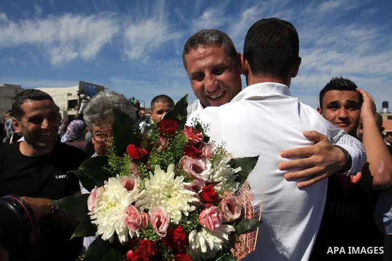 Freed Palestinian prisoners (C) are welcomed home by their friends and relatives upon their arrival in Ramallah, the West Bank, 18 October 2011. 477 Palestinian prisoners were freed on 18 October 2011 in exchange for the...