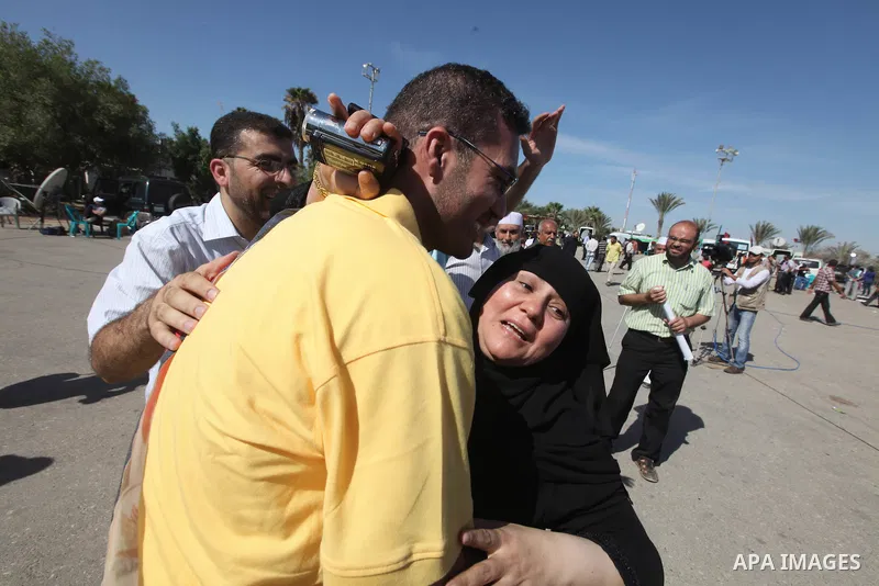 Palestinians greet their relative released Palestinian prisoner at the Rafah border crossing in southern Gaza Strip, Tuesday, Oct. 18, 2011. The Hamas militant group released an Israeli soldier Tuesday more than five yea...