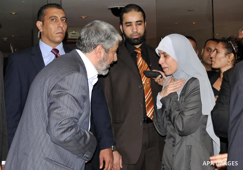 Hamas political leader Khaled Meshal, left, greets a Palestinian released prisoner upon his arrival in Cairo, Egypt, Tuesday, Oct.18, 2011 .Hundreds of Palestinians freed from Israeli prisons in exchange for the release...