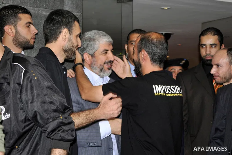 Hamas political leader Khaled Meshal, left, greets a Palestinian released prisoner upon his arrival in Cairo, Egypt, Tuesday, Oct.18, 2011 .Hundreds of Palestinians freed from Israeli prisons in exchange for the release...