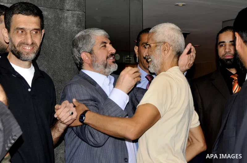 Hamas political leader Khaled Meshal, left, greets a Palestinian released prisoner upon his arrival in Cairo, Egypt, Tuesday, Oct.18, 2011 .Hundreds of Palestinians freed from Israeli prisons in exchange for the release...