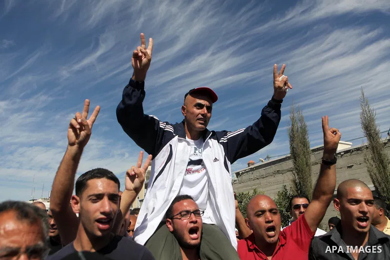 Palestinian prisoners are welcomed by a crowd following the release of hundreds of prisoners from Israeli jails on October 18,2011 at the Palestinian Authority headquarters in the West Bank city of Ramallah. Crowds of Pa...