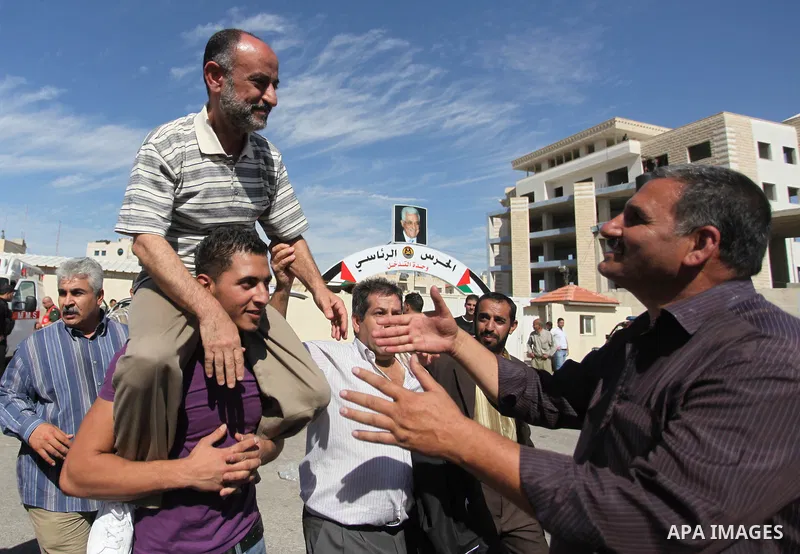 Palestinian prisoners are welcomed by a crowd following the release of hundreds of prisoners from Israeli jails on October 18,2011 at the Palestinian Authority headquarters in the West Bank city of Ramallah. Crowds of Pa...