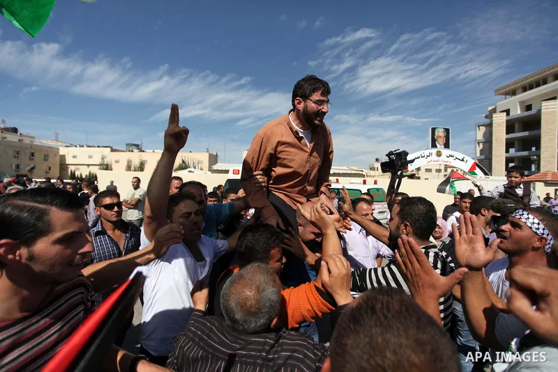 Palestinian prisoners are welcomed by a crowd following the release of hundreds of prisoners from Israeli jails on October 18,2011 at the Palestinian Authority headquarters in the West Bank city of Ramallah. Crowds of Pa...