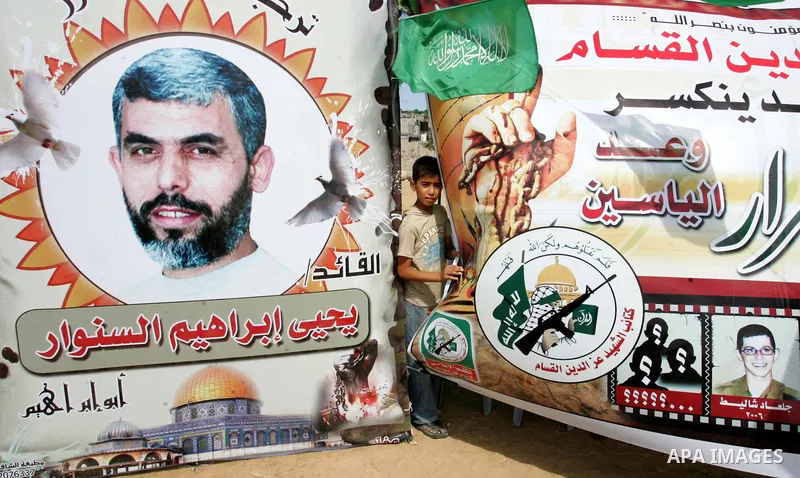 A Palestinian boy stands near a poster for a Hamas freed Palestinian prisoner, Yehia Sinwar laid upon his return in the southern Gaza Strip town of Khan Yunis on October 19, 2011. Israeli soldier Gilad Shalit and hundred...