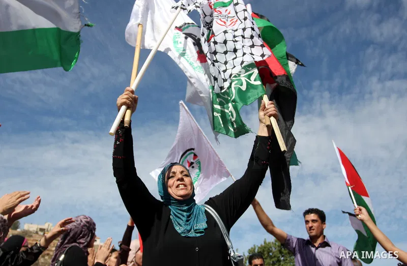 Palestinians wait at the Beituniya checkpoint for released Palestinian prisoners to cross into the West Bank city of Ramallah, Tuesday, Oct. 18, 2011. The Hamas militant group released an Israeli soldier Tuesday more tha...