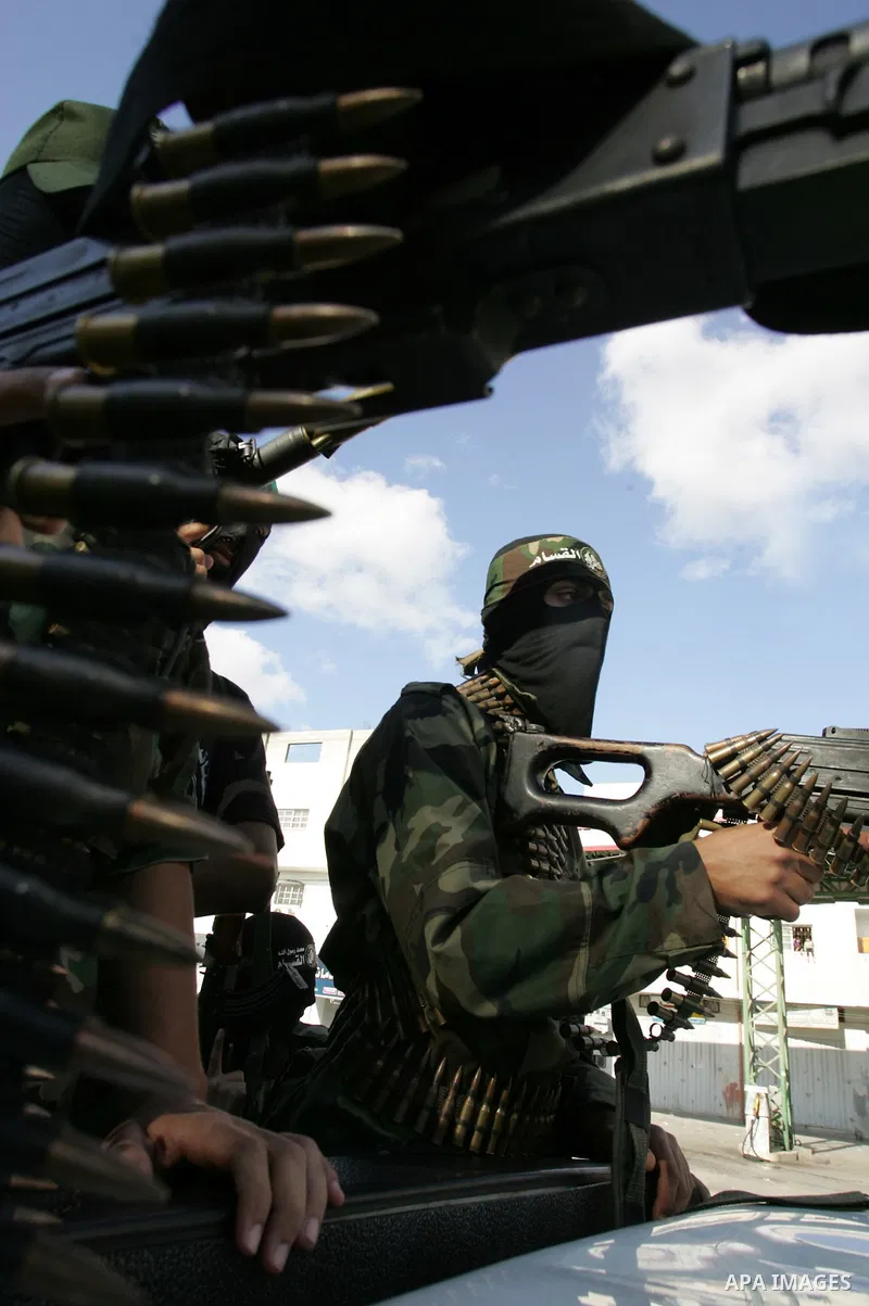Hamas militants pray before going to pay their respects to freed Palestinian prisoners in Rafah, southern Gaza Strip, Wednesday, Oct. 19, 2011. Tens of thousands of flag-waving Palestinians celebrated the homecoming of h...