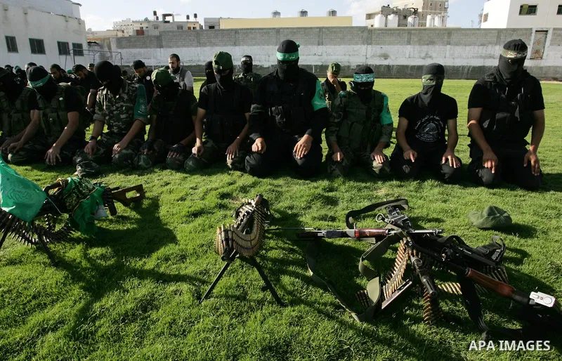 Hamas militants pray before going to pay their respects to freed Palestinian prisoners in Rafah, southern Gaza Strip, Wednesday, Oct. 19, 2011. Tens of thousands of flag-waving Palestinians celebrated the homecoming of h...