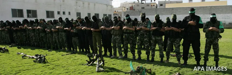 Hamas militants pray before going to pay their respects to freed Palestinian prisoners in Rafah, southern Gaza Strip, Wednesday, Oct. 19, 2011. Tens of thousands of flag-waving Palestinians celebrated the homecoming of h...