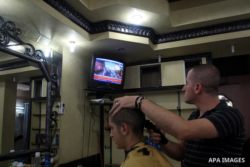 Palestinians watch television news the killing of the Libyan leader,in West Bank, City of Nablus. on October 20, 2011. Head of the military in the city of Tripoli, "Abdel Hakim Belhadj, " the killing of Libyan leader ous...