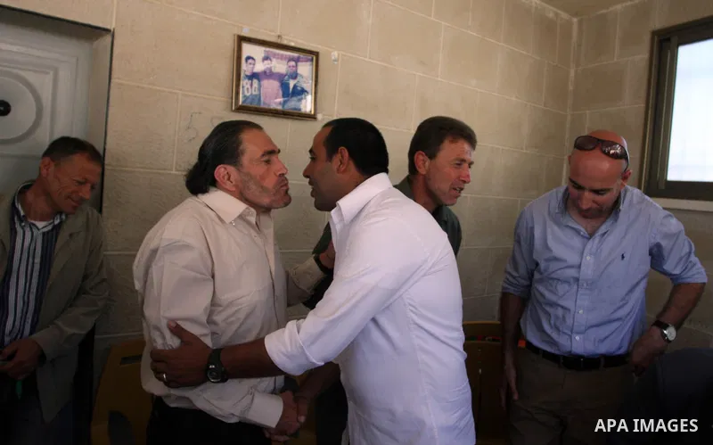 Freed Palestinian prisoner Fakhri Barghoutia, 53,who served 33 years in jail, more time than any other Palestinian released in a trade for Israeli soldier Gilad Shalit, greets a child along with Nael Barghoutia 54 years,...