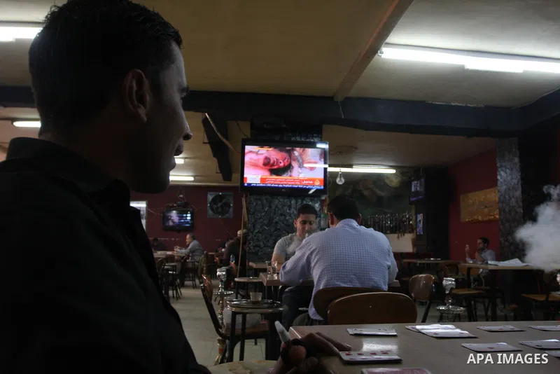 Palestinians watch television news the killing of the Libyan leader,in West Bank, City of Ramallah, on October 20, 2011. Head of the military in the city of Tripoli, "Abdel Hakim Belhadj, " the killing of Libyan leader o...