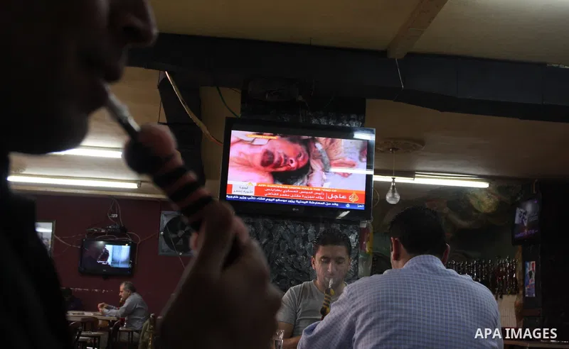 Palestinians watch television news the killing of the Libyan leader,in West Bank, City of Ramallah, on October 20, 2011. Head of the military in the city of Tripoli, "Abdel Hakim Belhadj, " the killing of Libyan leader o...