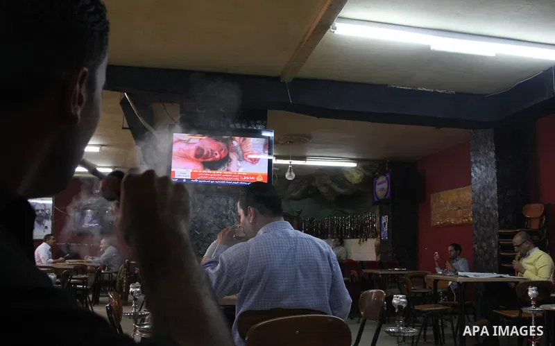 Palestinians watch television news the killing of the Libyan leader,in West Bank, City of Ramallah, on October 20, 2011. Head of the military in the city of Tripoli, "Abdel Hakim Belhadj, " the killing of Libyan leader o...