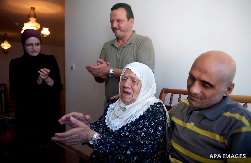 Freed Palestinian prisoner Samer Abu Sir listens to his 96 year old mother sing at Hanadi Tower, where he is staying, exiled upon his release from Israeli jail, in Gaza City October 20, 2011. His family came from East Je...
