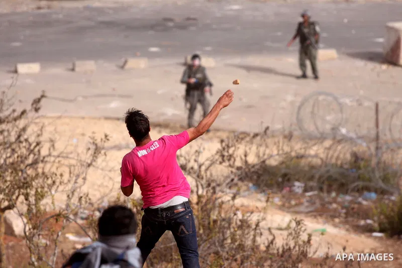 A Palestinian protester hurls stones at Israeli security forces during clashes outside Israeli military prison Ofer near the West Bank city of Ramallah. Friday, Oct. 21, 2011. Photo by Issam Rimawi