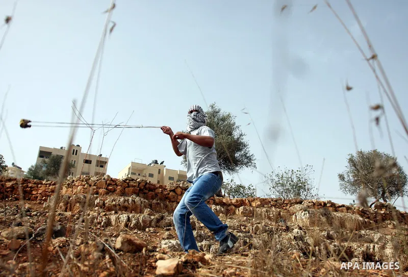 A Palestinian protester hurls stones at Israeli security forces during clashes outside Israeli military prison Ofer near the West Bank city of Ramallah. Friday, Oct. 21, 2011. Photo by Issam Rimawi