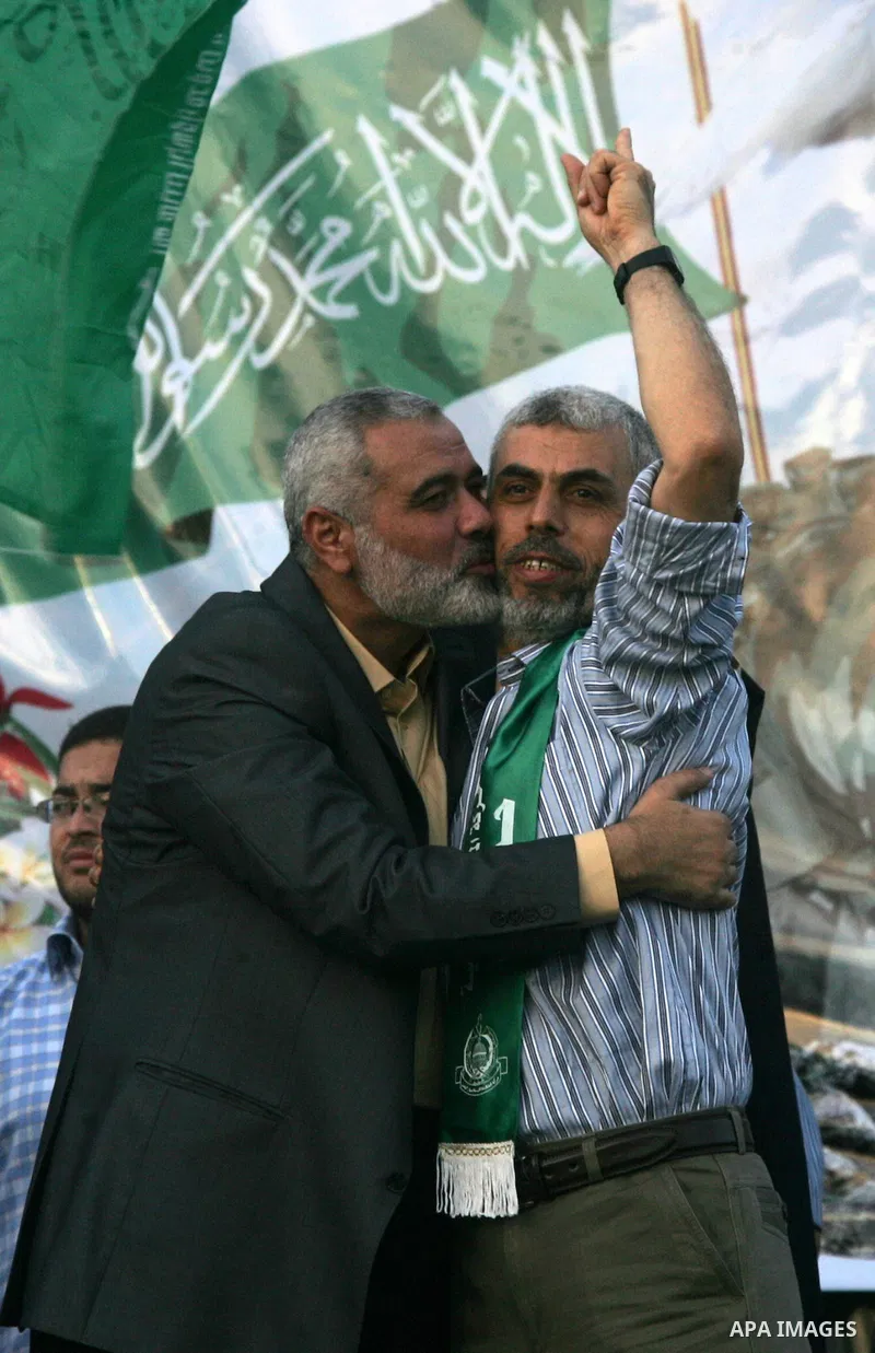 Hamas leader Ismail Haniya kisses freed Palestinian prisoner Yehiye Sinwar, a founder of Hamas' military wing, wave as Hamas supporters celebrate the release of hundreds of prisoners following a swap with captured Israel...