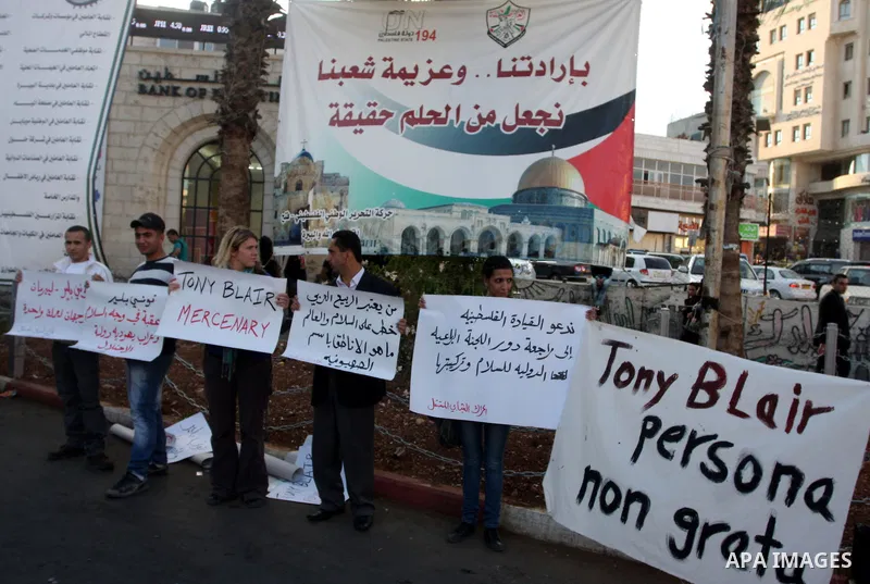Palestinians hold placards against the policy of the Quartet envoy in the Middle East Tony Blair during a protest in the West Bank city of Ramallah. On October 26, 2011. Palestinian protesters demanded the departure of T...
