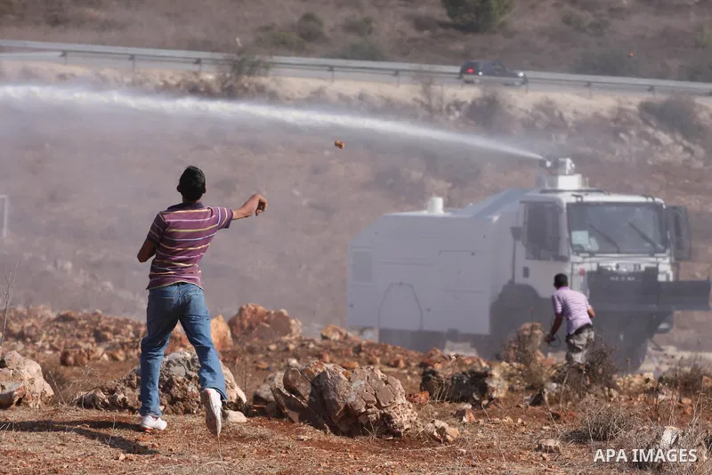Palestinian youths hurl stones towards Israeli soldiers during clashes following a weekly demonstration against Israeli settlement expansion, in the West Bank village of Nabi Saleh, on October 28, 2011. Photo by Issam Ri...