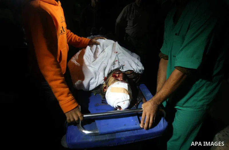 Palestinian men carry the body of a militant member of the radical movement Islamic Jihad cries next to his body at al Shifa hospital following an Israeli airstrike in the west of Gaza City on Oct. 29, 2011. Two Islamic...