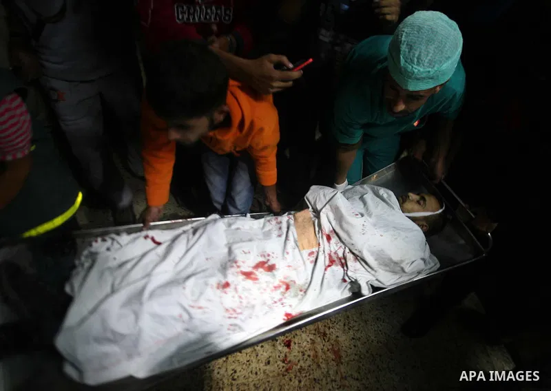 Palestinian men carry the body of a militant member of the radical movement Islamic Jihad cries next to his body at al Shifa hospital following an Israeli airstrike in the west of Gaza City on Oct. 29, 2011. Two Islamic...