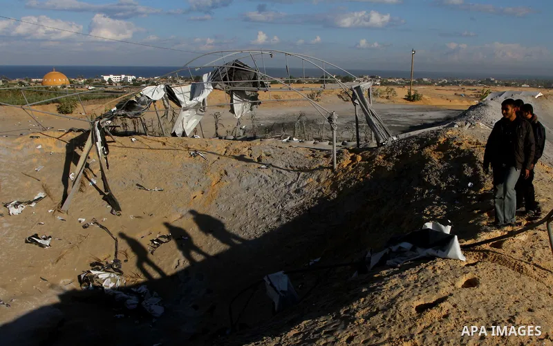 Palestinians survey a militant training base damaged in an Israeli air strike in Khan Younis in the southern Gaza Strip October 30, 2011. An Egyptian-brokered truce failed to take effect as planned on Sunday to halt a fl...