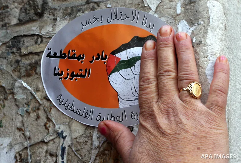 Palestinian demonstrators carry posters and graphics demanding merchants to boycott Israeli settlement products during a protest in the West Bank city of Ramallah October 30,2011. Photo by Issam Rimawi