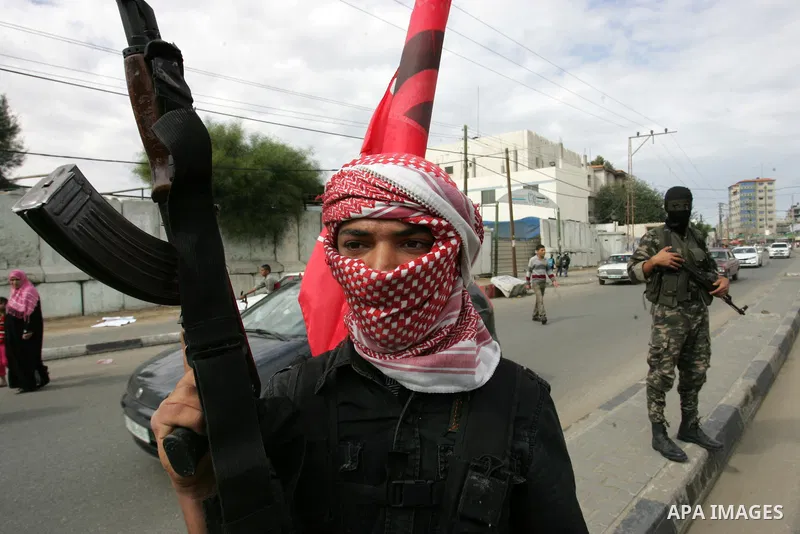 A Palestinian Democratic Front for the Liberation of Palestine militant shoots in the air during the funeral of DFLP militant Ahmed Jargon, killed in an Israeli strike on Sunday, in Rafah, southern Gaza Strip, Monday, Oc...