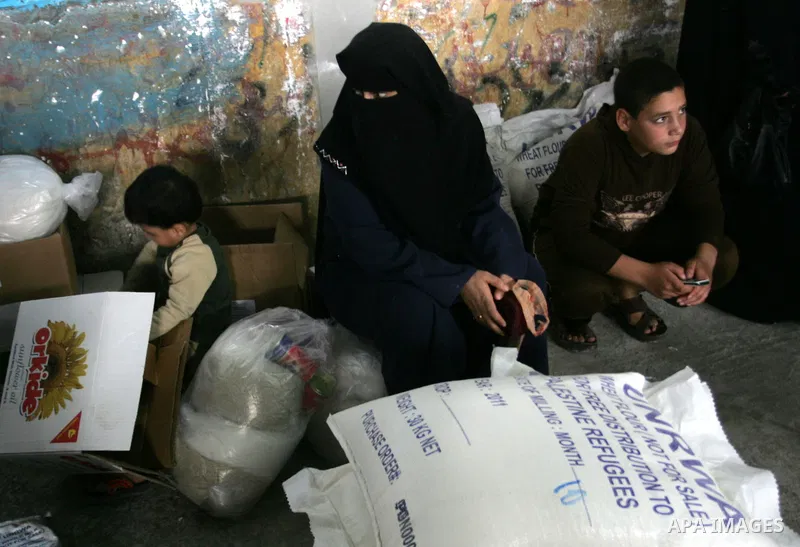 Palestinians collect food aid from the United Nations Relief and Works Agency (UNRWA) in the Rafah refugee camp, southern Gaza Strip, on November 01, 2011. Palestine became a full member of the U.N. cultural and educatio...