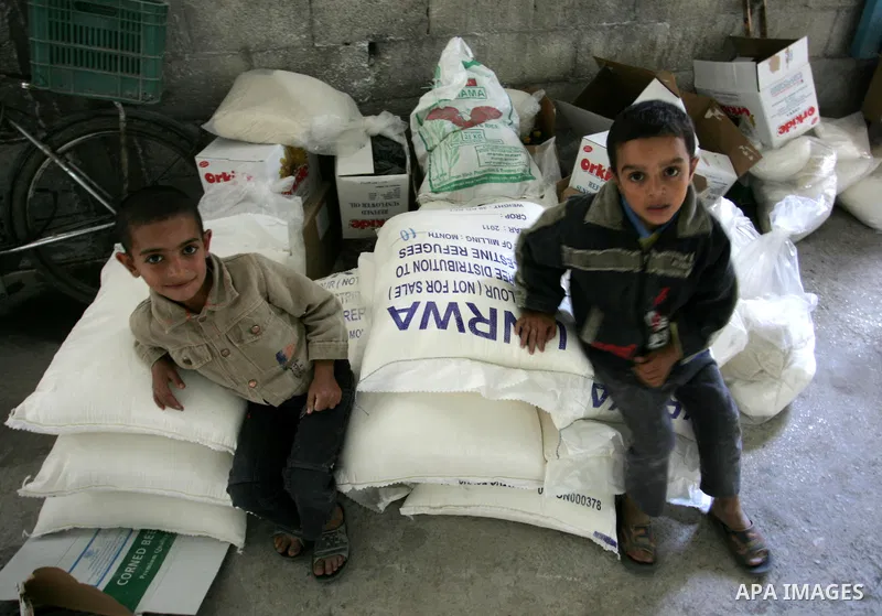 Palestinians collect food aid from the United Nations Relief and Works Agency (UNRWA) in the Rafah refugee camp, southern Gaza Strip, on November 01, 2011. Palestine became a full member of the U.N. cultural and educatio...